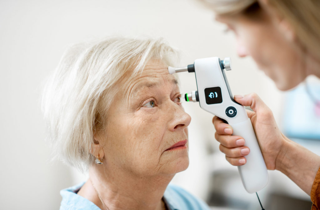 Senior woman has her eye pressure tested with a tonometer.